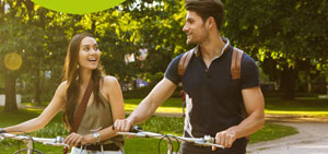 Zwei Studierende mit Fahrrädern im Park