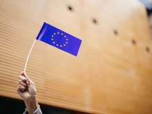 Hand hält Europaflagge als Papierfähnchen in die Höhe