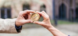 Symbolbild: zwei Hände halten einen antiken Kompass