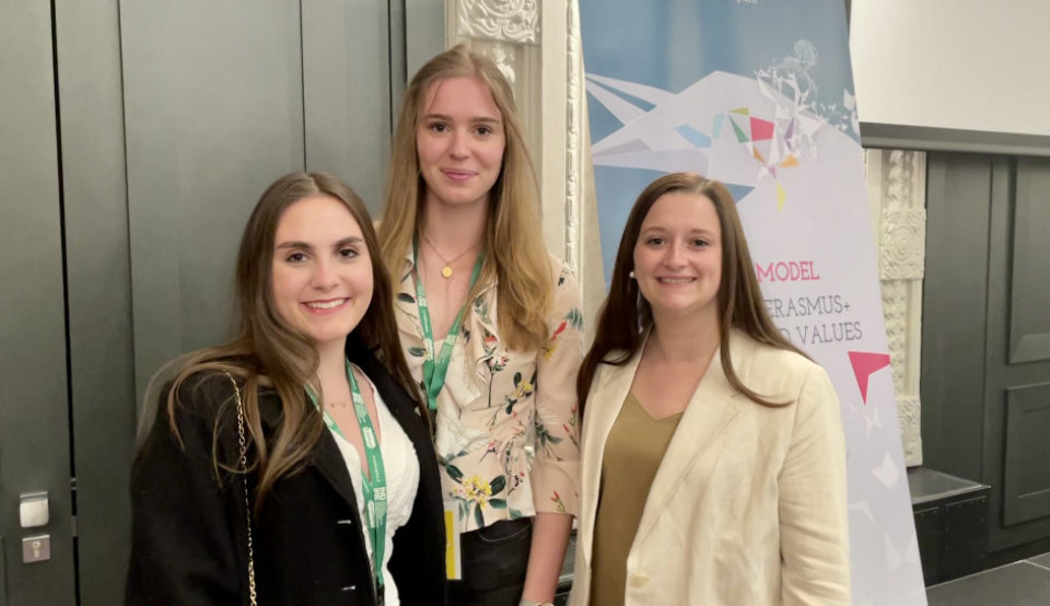 Drei Erasmus-Studentinnen vor einem Roll-Up der TCA in Florenz
