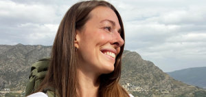 Die Studentin Jorina Arbeiter lächelt in die Kamera, während Sie im Hinterland von Barcelona wandern geht.
