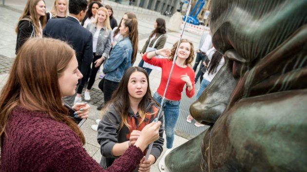Schülerinnen vermessen eine Bronzeskulptur