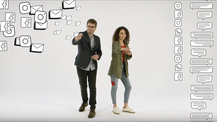 Ein junger Mann und eine junge Frau werfen Social Media Icons an den Bildschirm.