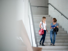 Zwei Studierende besprechen Jean Monnet-Aktivitäten im Treppenhaus ihrer Universität.