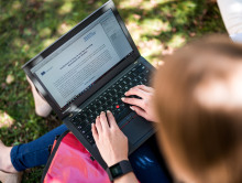 Studentin arbeitet im Freien an ihrem Laptop