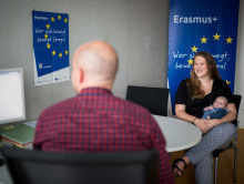 Ein Hochschulkoordinator berät eine Mutter mit ihrem Kind zur Erasmus+ Förderung.