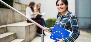 Eine Studierende hält lächelnd ihren Erasmus+ Antrag in den Händen.