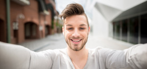 Ein Erasmus+ Student macht lächelnd ein Selfie.